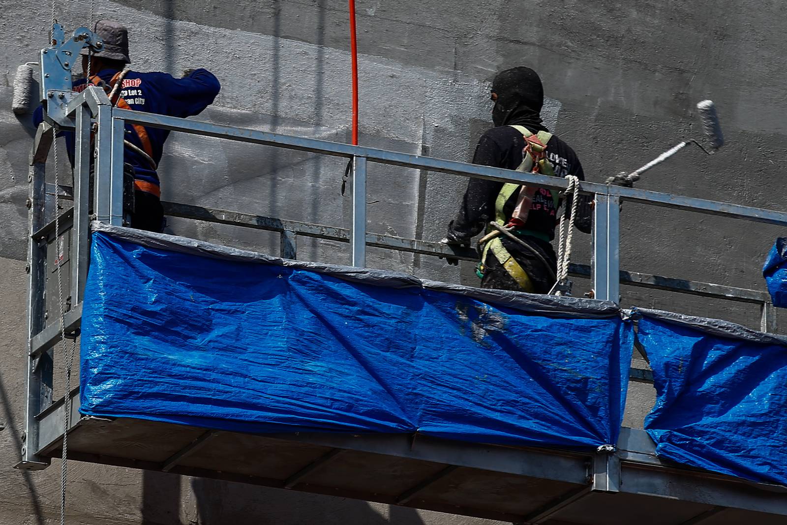 High-rise workers apply waterproofing to a building in Manila on 26 October 2026, as the Department of Labor and Employment clarifies compensation coverage for heat-related illnesses under the Employees’ Compensation Program amid the “super” El Niño and extreme heat.
