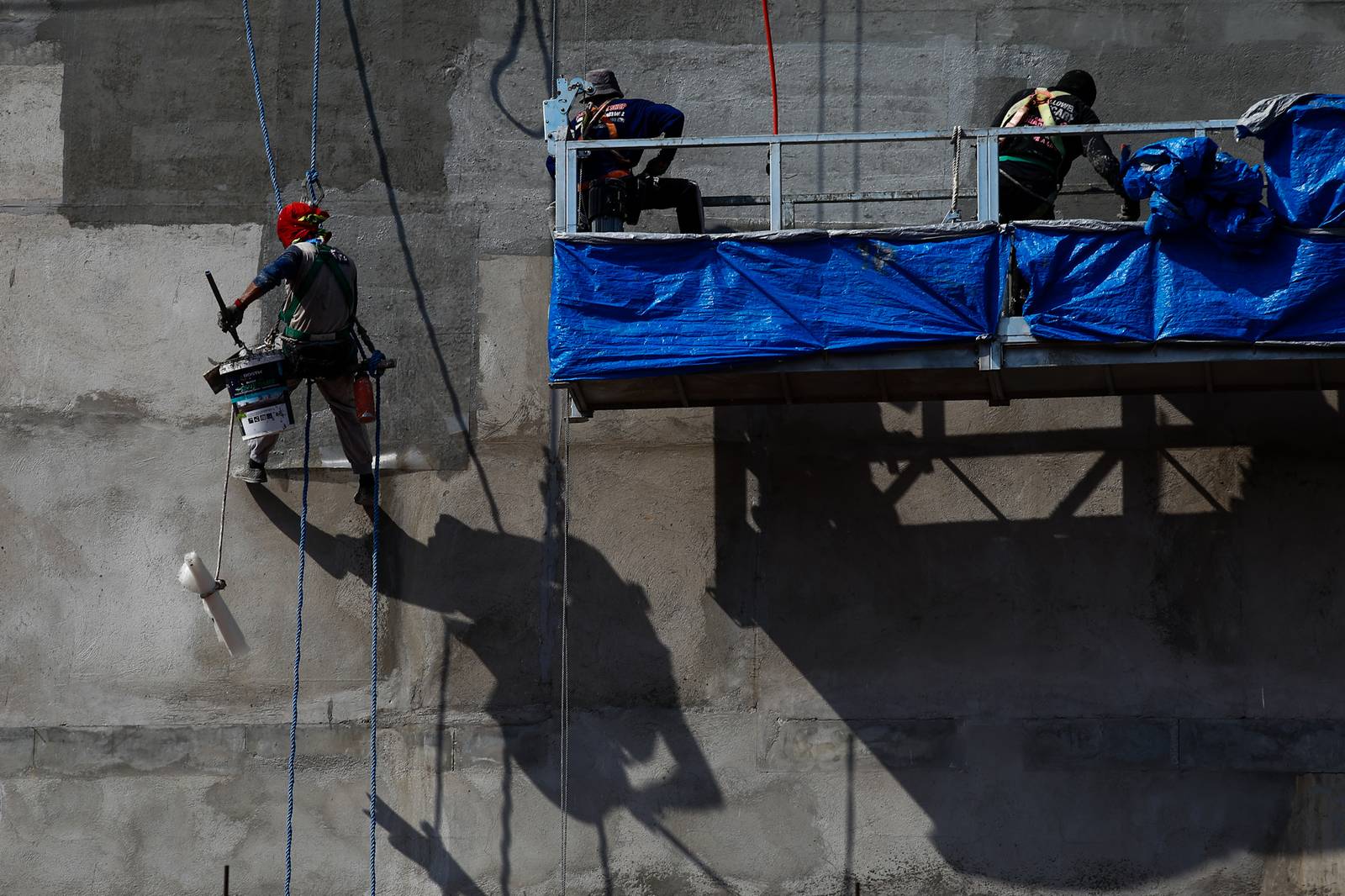 High-rise workers apply waterproofing to a building in Manila on 26 October 2026, as the Department of Labor and Employment clarifies compensation coverage for heat-related illnesses under the Employees’ Compensation Program amid the “super” El Niño and extreme heat.