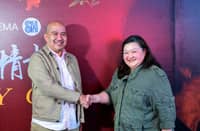 PLDT Global head of Consumer Ecosystem and Growth Jules Salonga (left) and SM Prime Holdings Inc. vice president for Cinema Marketing Myra Moñozca seal a partnership aimed at connecting overseas Filipino workers with their families in the Philippines through shared cinema experiences.