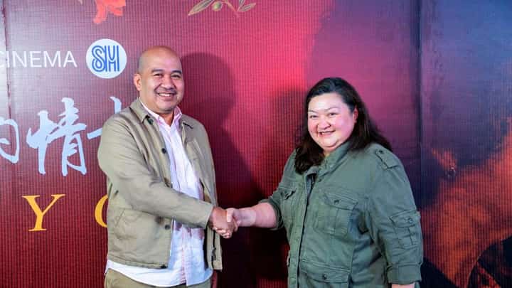 PLDT Global head of Consumer Ecosystem and Growth Jules Salonga (left) and SM Prime Holdings Inc. vice president for Cinema Marketing Myra Moñozca seal a partnership aimed at connecting overseas Filipino workers with their families in the Philippines through shared cinema experiences.