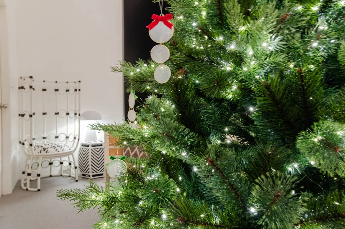 CHRISTMAS Tree with white LED string lights and hanging circle ornaments.