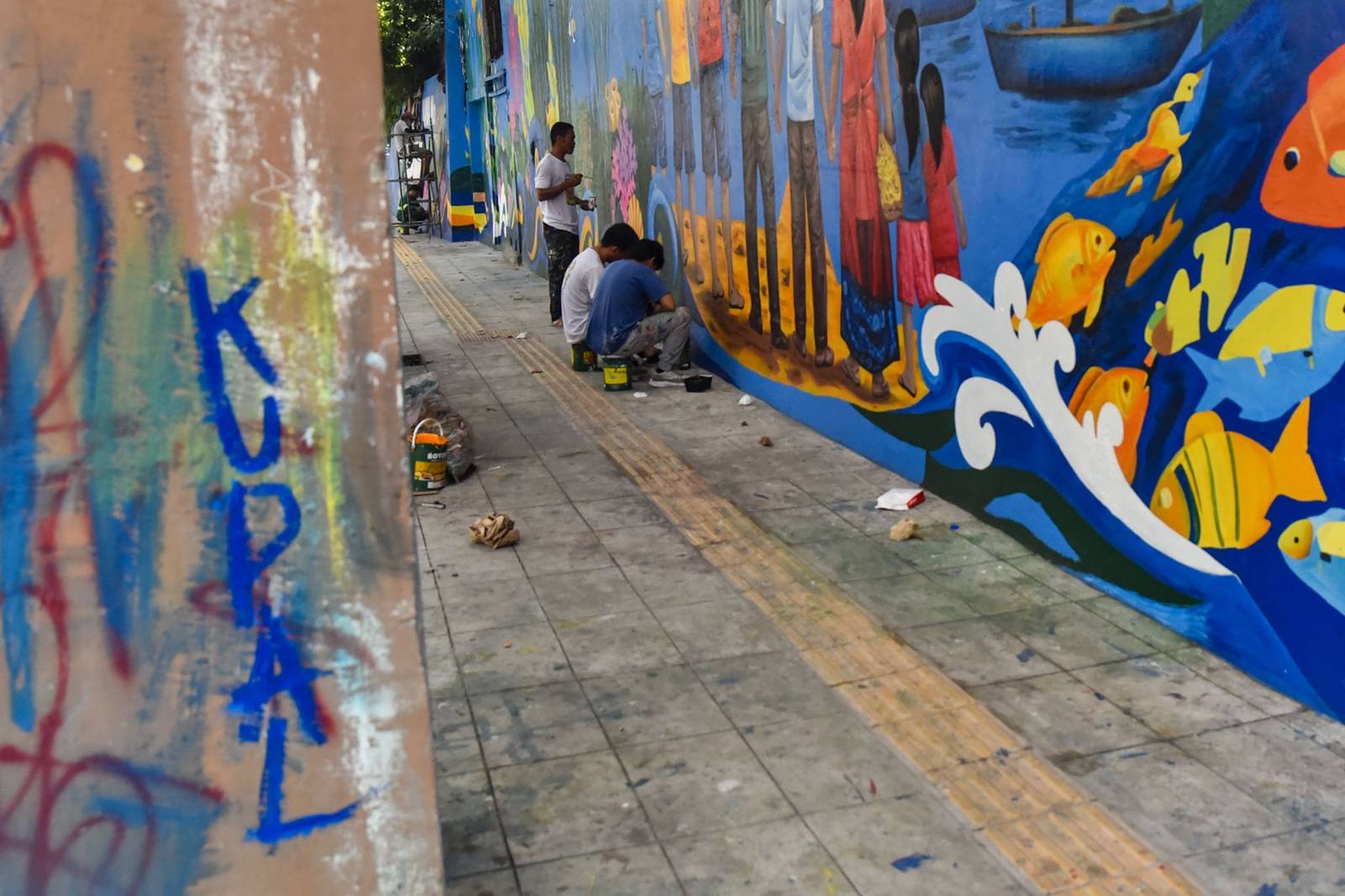 Workers paint a section of a mural along EDSA on October 31. l Zedrich Xylak Madrid