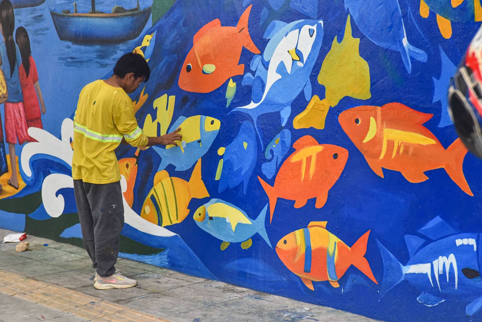 Workers paint a section of a mural along EDSA on October 31. l Zedrich Xylak Madrid