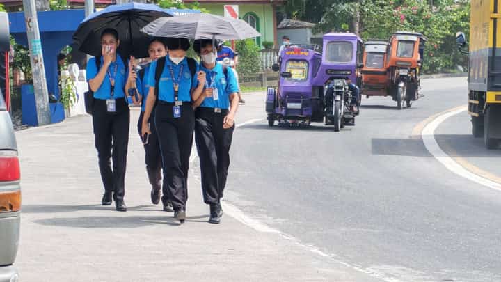 Residents waqlk through mild ashfall in Guinobatan, Albay