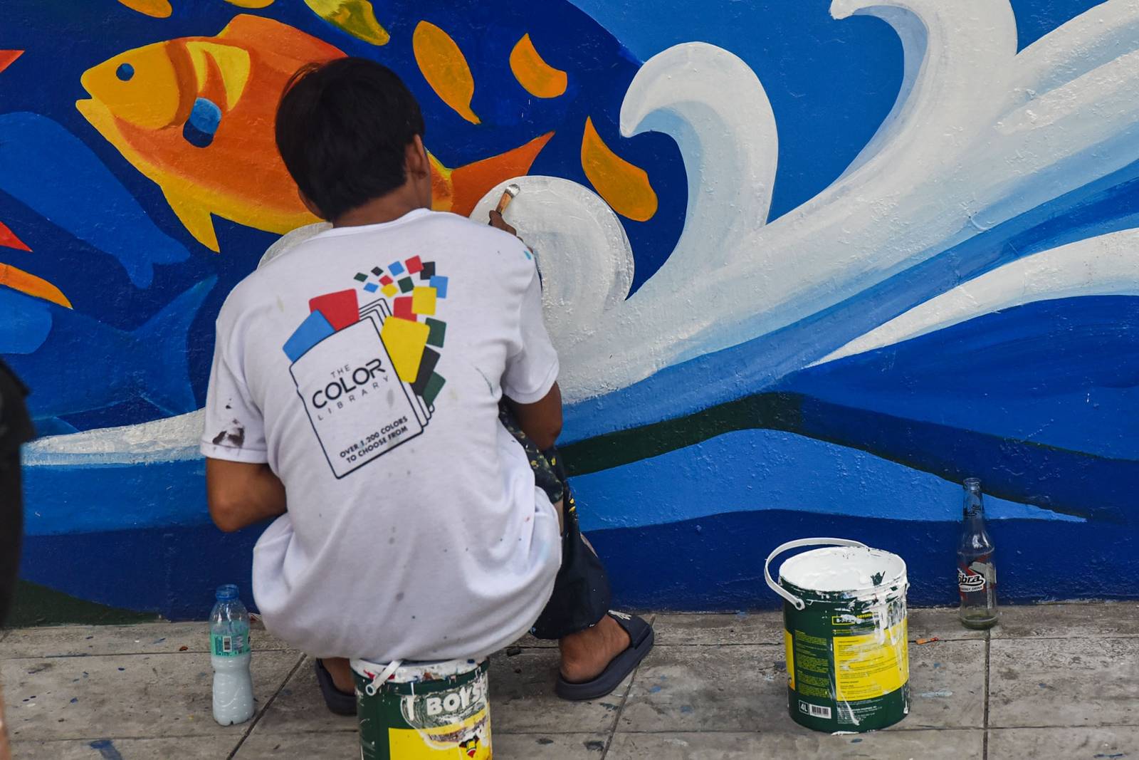 Workers paint a section of a mural along EDSA on October 31. l Zedrich Xylak Madrid