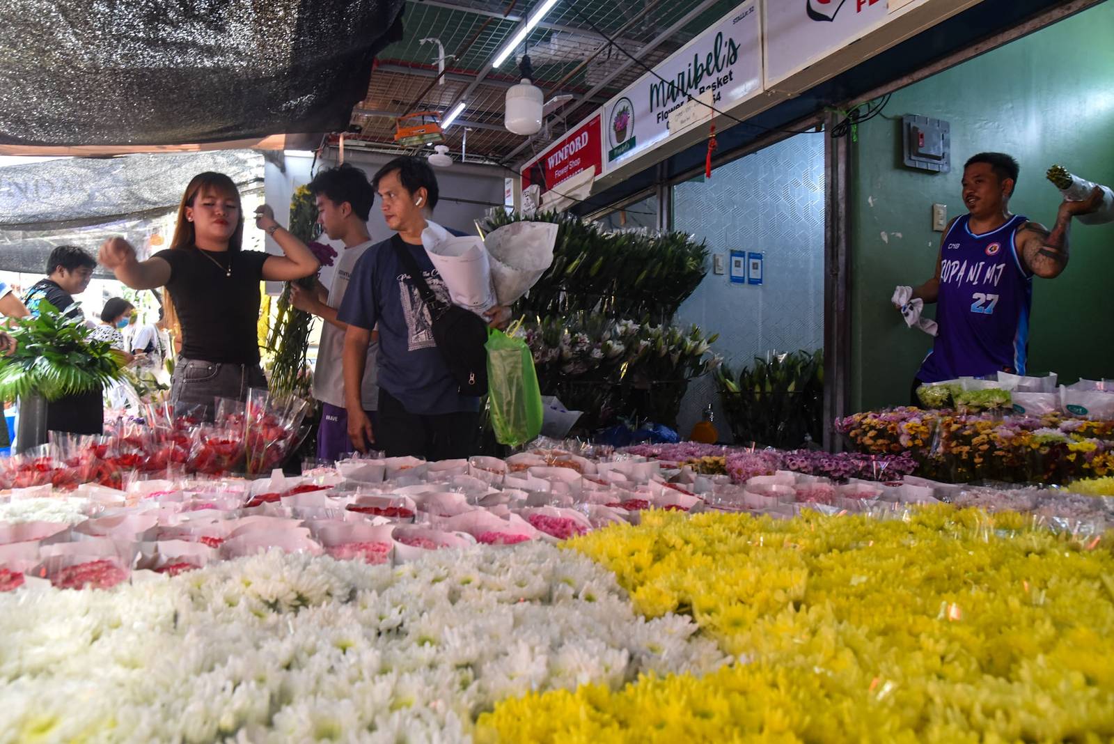 Families shop for flowers at Dangwa Flower Market in Manila as they prepare to honor and remember their departed loved ones ahead of Undas observance, October 31. l Zedrich Xylak Madrid