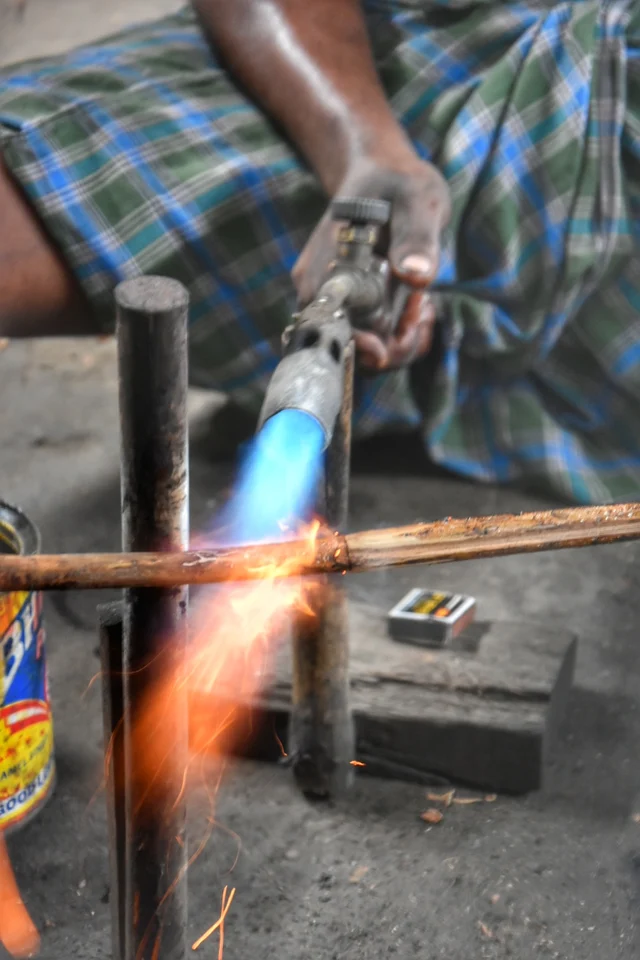 மூங்கில் பிரம்புகளை நெருப்பில் காட்டி வளைப்பது